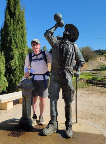 Thirsty pilgrim statue by the well (still in use). Water runs out of the pilgrim's jar when the well is used.